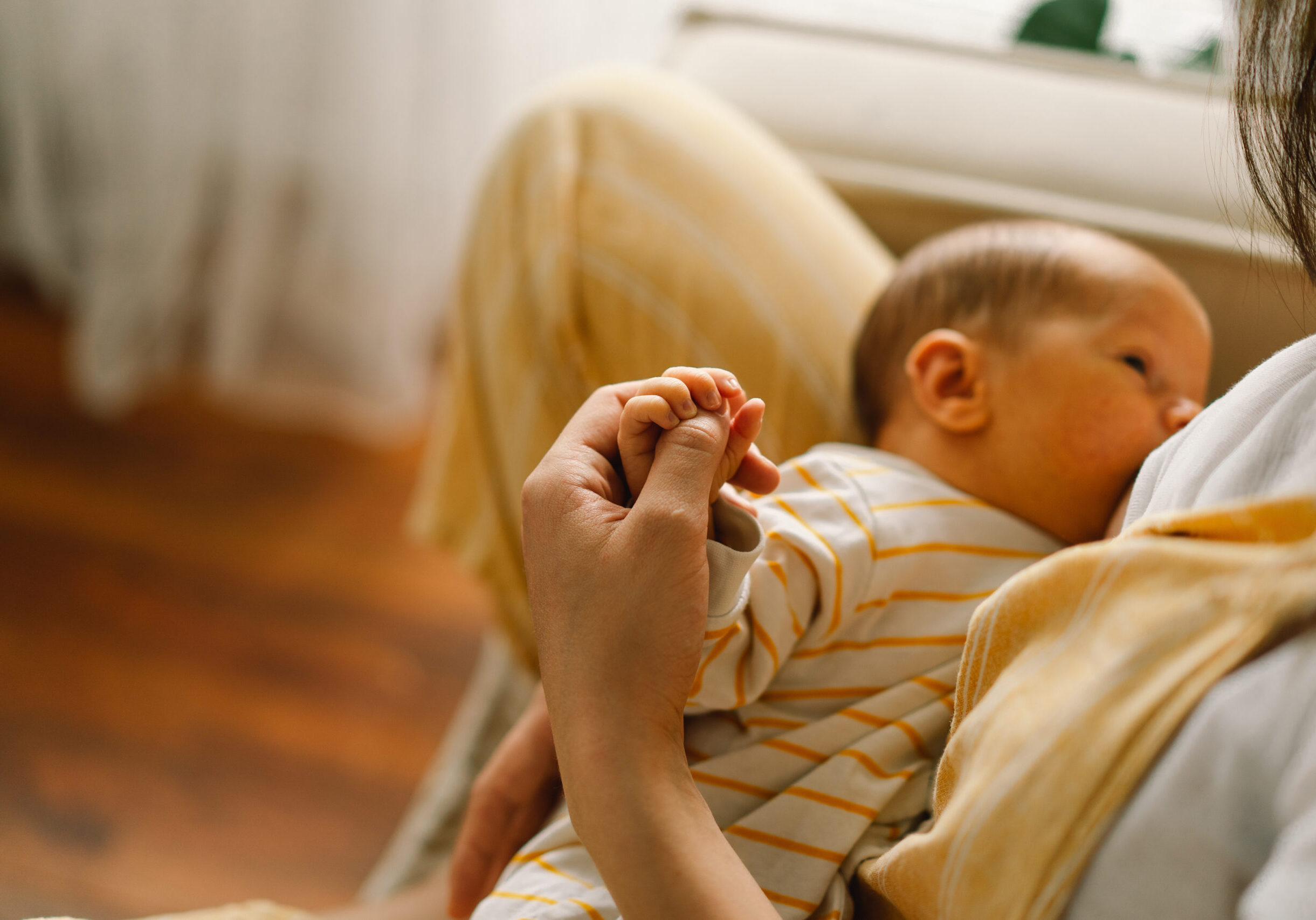 Newborn baby boy sucking milk from mothers breast. Portrait of mom and breastfeeding baby. Concept of healthy and natural baby breastfeeding nutrition.